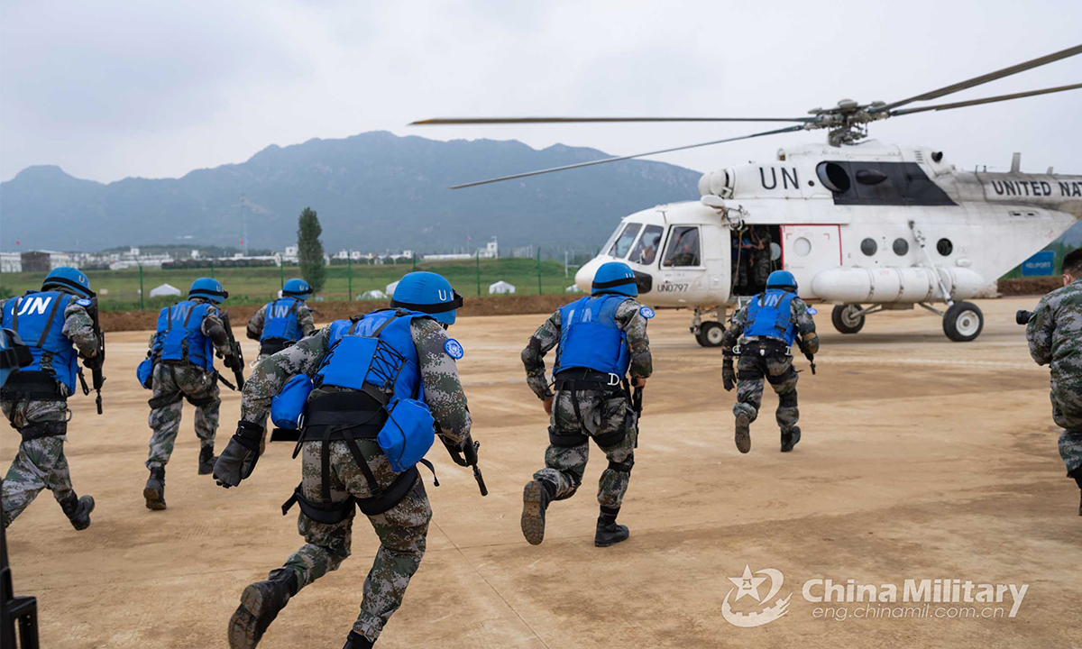 Chinese peacekeeping special operations soldiers of the quick reaction force (QRF) disembark from an off-road tactical armored vehicle and rush to board a transport helicopter during the lane training stage of the Shared Destiny-2021 UN peacekeeping field training exercise in Queshan, Henan Province on September 9, 2021. (eng.chinamil.com.cn/Photo by Wan Quan)