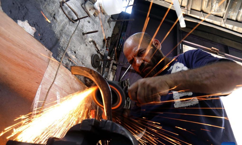 A blacksmith makes agricultural tools at a workshop in Baghdad, Iraq, on Sept. 12, 2021. Iraqi blacksmith Ali al-Khazraji uses his technical expertise to turn scrap iron from old cars into useful agricultural tools such as blades, shovels, axes and sickles.Photo: Xinhua 