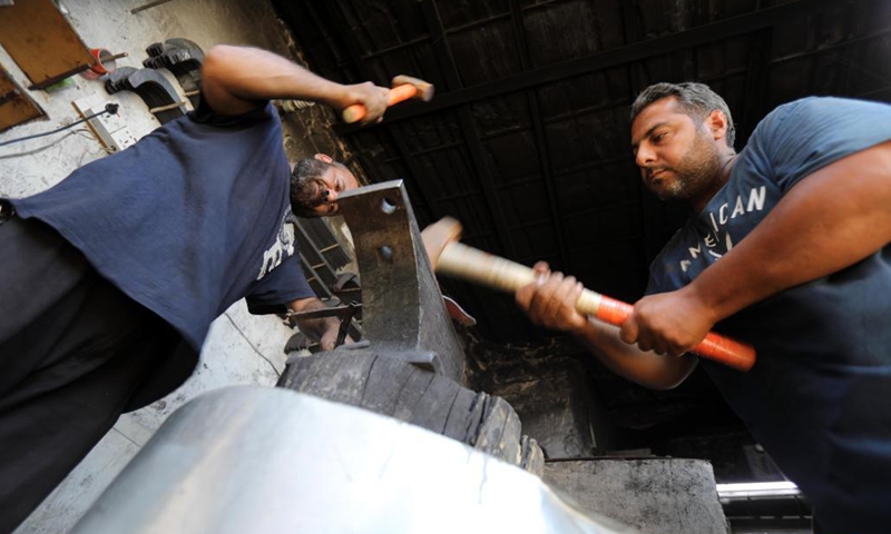 Blacksmiths make agricultural tools at a workshop in Baghdad, Iraq, on Sept. 12, 2021. Iraqi blacksmith Ali al-Khazraji uses his technical expertise to turn scrap iron from old cars into useful agricultural tools such as blades, shovels, axes and sickles.Photo: Xinhua 