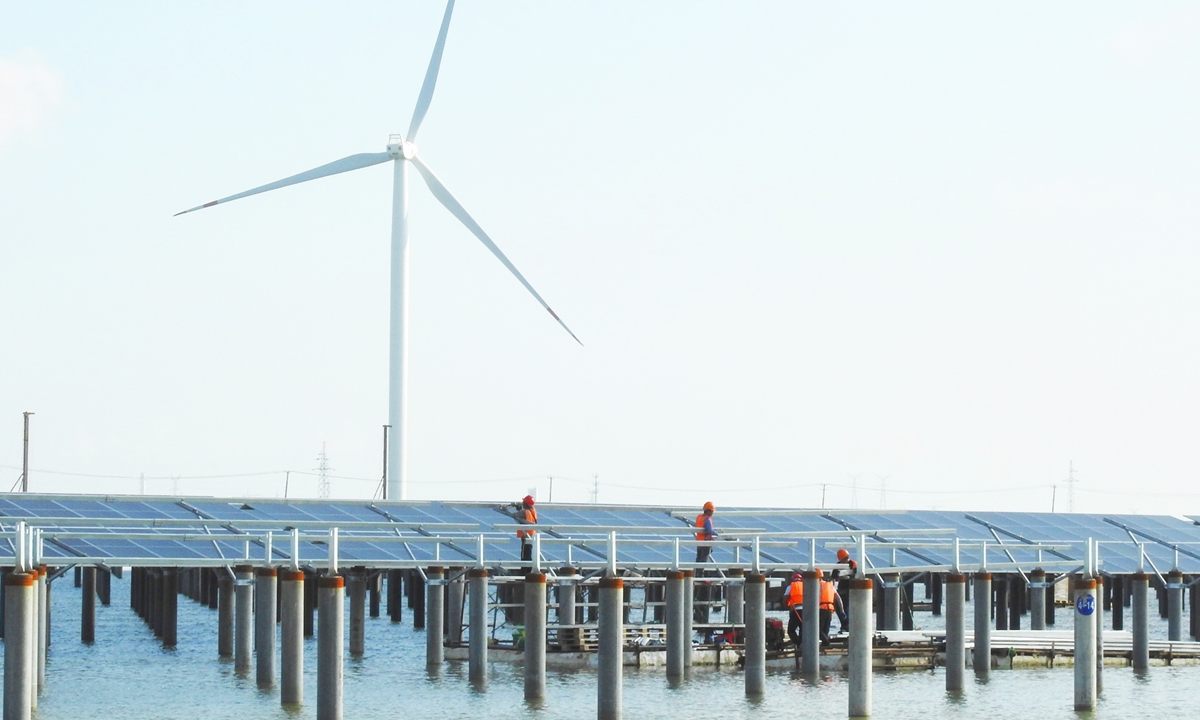 Workers install solar panels at a solar power plant in Lianyungang, East China's Jiangsu Province on Tuesday. The plant is being built over fish ponds, as part of an innovative photovoltaic demonstration projects. Once completed, it will have an installed capacity of 200 megawatts. Photo: cnsphoto