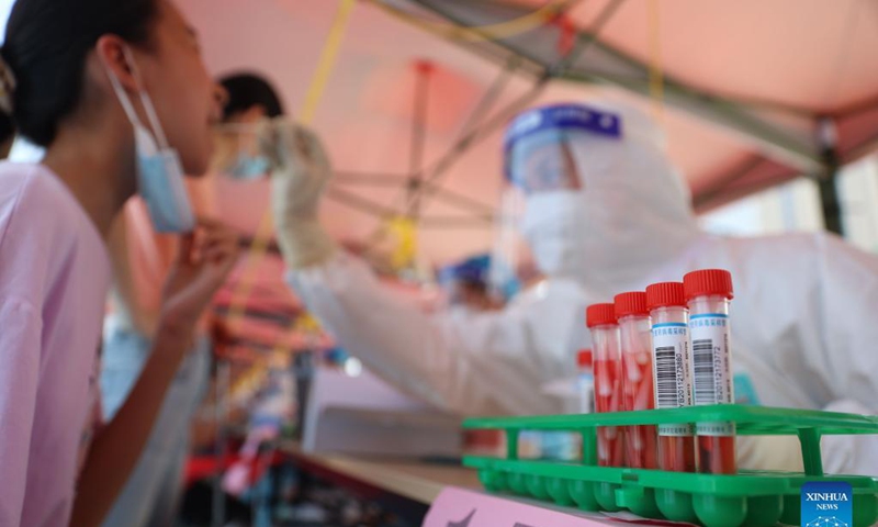 A medical worker collects a swab sample for nucleic acid testing at a testing site in a community in Siming District, Xiamen, southeast China's Fujian Province, Sept. 14, 2021.Photo:Xinhua