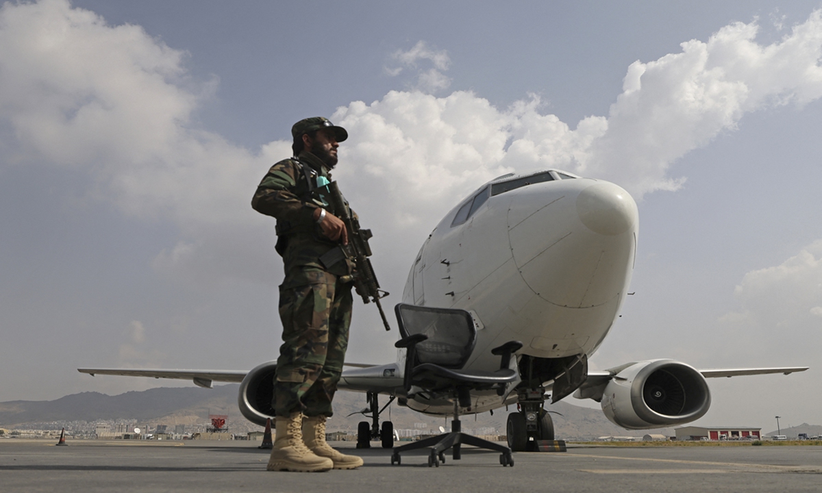A Taliban fighter stands guard next to an aircraft at the Kabul airport on September 12. Photo:AFP
