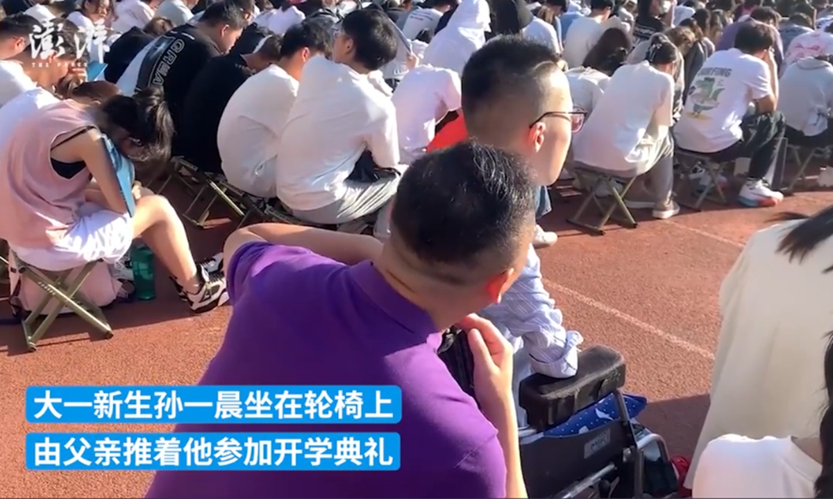 A father in Xi'an, Northwest China's Shaanxi Province, who took his son in a wheelchair for a school opening ceremony on Monday has attracted a lot of attention from netizens. Photo: A screenshout of a video by The Paper
