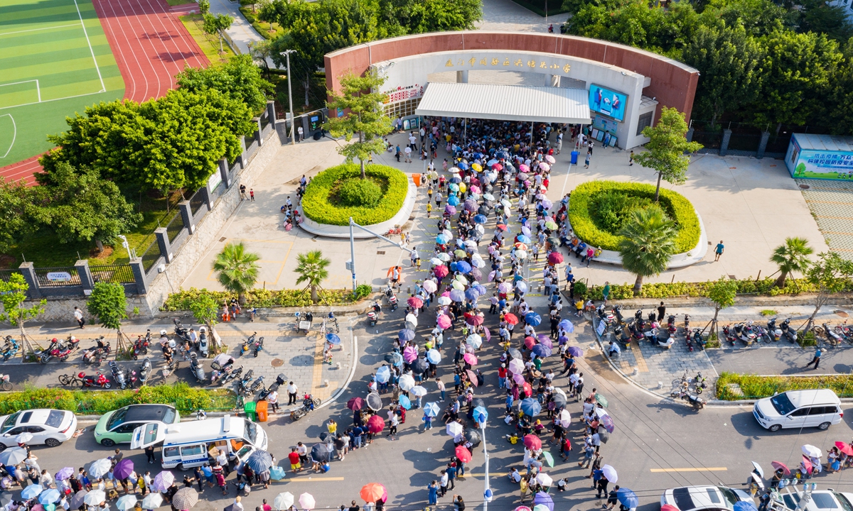 Residents in Xiamen, East China's Fujian Province, line up for their COVID-19 nucleic acid testing at a local elementary school on September 14. In-person classes were suspended after 35 cases were confimred in the city. Photo: VCG