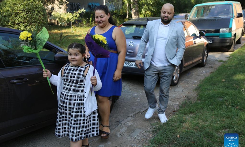 A girl goes to school with her parents' company for the new school year in Sofia, Bulgaria, Sept. 15, 2021. Despite the severe COVID-19 pandemic in Bulgaria, all the 2,357 schools across the country opened their classrooms for the new school year.Photo: Xinhua