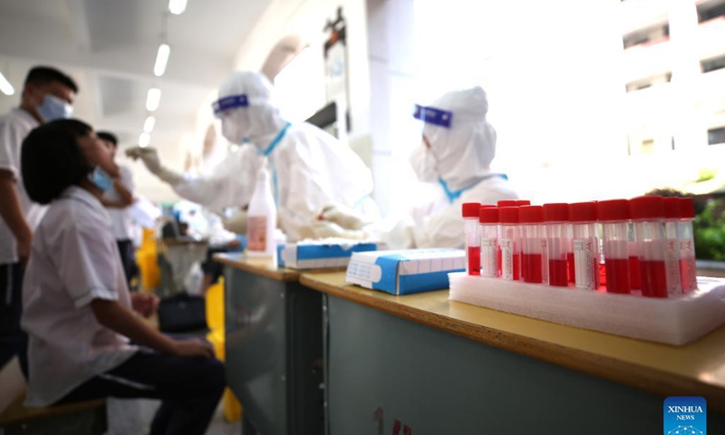 A medical worker collects a swab sample from a student for nucleic acid testing at No. 9 middle school in Longyan, southeast China's Fujian Province, Sept. 15, 2021. Recently, a new round of nucleic acid testing has been launched for all teachers, students and staff in schools in Fujian province due to the latest COVID-19 resurgence.Photo: Xinhua