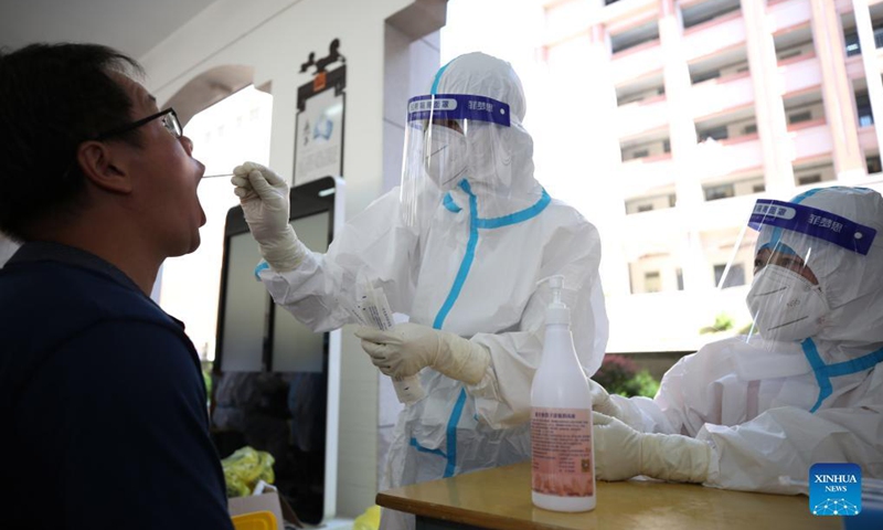A medical worker collects a swab sample from a student for nucleic acid testing at No. 9 middle school in Longyan, southeast China's Fujian Province, Sept. 15, 2021. Recently, a new round of nucleic acid testing has been launched for all teachers, students and staff in schools in Fujian province due to the latest COVID-19 resurgence.Photo: Xinhua