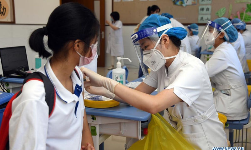 A medical worker administers a dose of COVID-19 vaccine to a girl student at the Hangtian Campus of the Beijing Yuying School in Beijing, capital of China, on Aug. 21, 2021.(Xinhua)