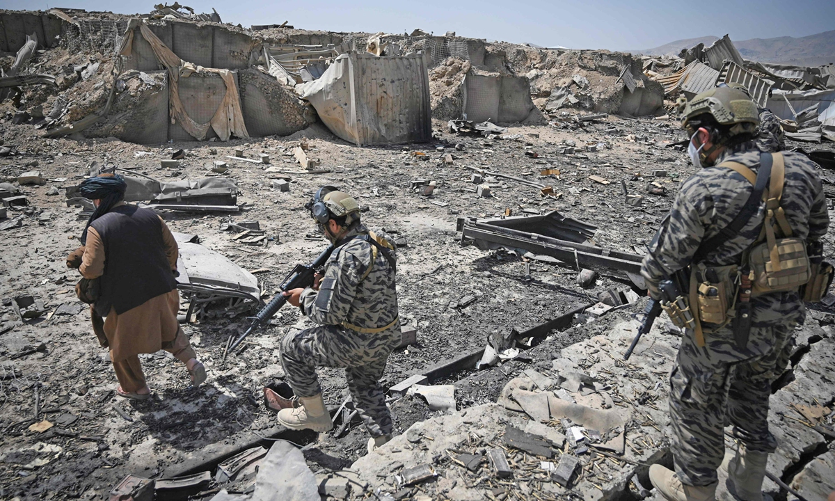 Members of the Taliban military unit walk amid debris of the destroyed Central Intelligence Agency base bombed out by US troops before they full withdrawal&nbsp;in Kabul on September 6.&nbsp;Photo: VCG