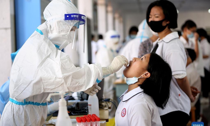 A medical worker collects a swab sample from a student for nucleic acid testing at No. 9 middle school in Longyan, southeast China's Fujian Province, Sept. 15, 2021. Recently, a new round of nucleic acid testing has been launched for all teachers, students and staff in schools in Fujian province due to the latest COVID-19 resurgence. Photo: Xinhua