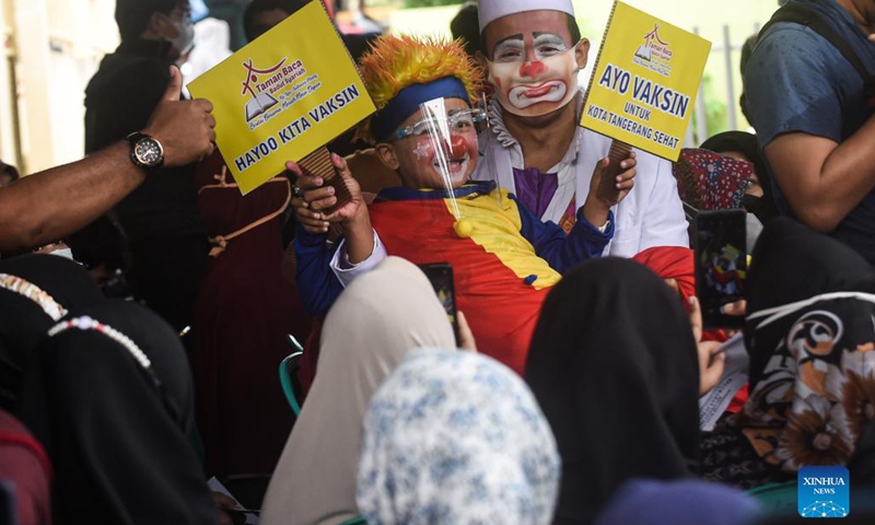 Members of a clown community hold placards with epidemic prevention and control slogans amid a COVID-19 vaccination campaign in Tangerang, Indonesia, Sept. 14, 2021.(Photo: Xinhua)
