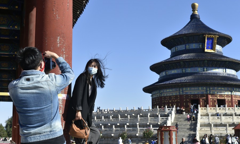 A tourist poses for photos with the Temple of Heaven during the National Day and Mid-Autumn Festival holiday in Beijing, capital of China, Oct. 4, 2020. Photo: Xinhua