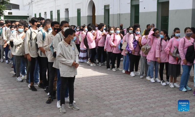 Students wearing face masks wait to enter a school on the first day of a new school year in Tunis, Tunisia, on Sept. 15, 2021. (Photo: Xinhua)