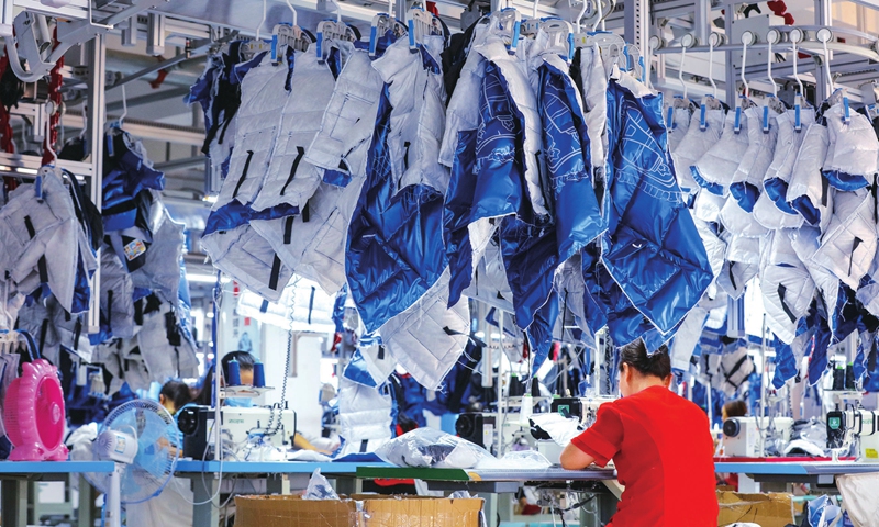 Female workers make down jackets at a factory in Guangshan county, Central China's Henan Province on Thursday. The local down feather industry supports a workforce of over 120,000 people, with annual sales reaching more than 7 billion yuan ($1.09 billion). Photo: cnsphoto