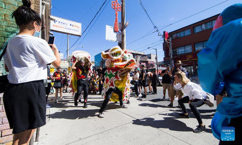 People perform a lion dance at the Chinatown in Toronto, Canada, on Sept. 18, 2021. A traditional lion dance parade was held here on Saturday to celebrate the upcoming Mid-Autumn Festival. (Photo by Zou Zheng/Xinhua)