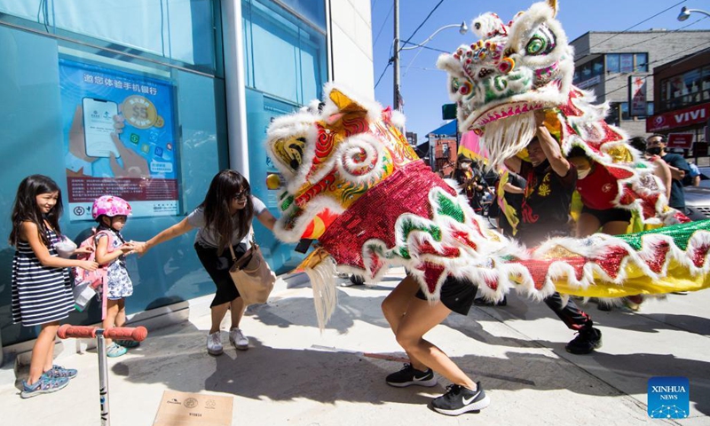 People perform a lion dance at the Chinatown in Toronto, Canada, on Sept. 18, 2021. A traditional lion dance parade was held here on Saturday to celebrate the upcoming Mid-Autumn Festival. (Photo by Zou Zheng/Xinhua)