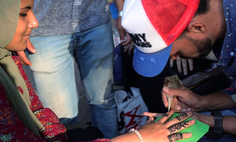 A man does hand painting for a tourist at the Giza Zoo in Giza, Egypt, on Sept. 18, 2021. Opened in 1891 and as the largest zoo in Egypt and the Middle East, Giza Zoo is a main destination for Egyptian families with their children on holidays. (Xinhua/Wang Dongzhen)