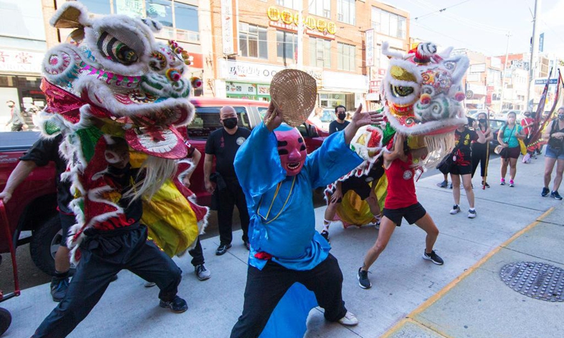 People perform a lion dance at the Chinatown in Toronto, Canada, on Sept. 18, 2021. A traditional lion dance parade was held here on Saturday to celebrate the upcoming Mid-Autumn Festival. (Photo by Zou Zheng/Xinhua) 