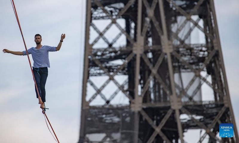 French highliner Nathan Paulin performs on a 70-meter-high slackline spanning 670 meters between the Eiffel Tower and the Theater National de Chaillot in Paris, France, on Sept. 18, 2021. (Xinhua)