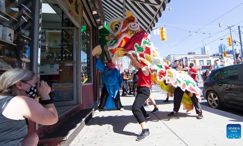 People perform a lion dance at the Chinatown in Toronto, Canada, on Sept. 18, 2021. A traditional lion dance parade was held here on Saturday to celebrate the upcoming Mid-Autumn Festival. (Photo by Zou Zheng/Xinhua)