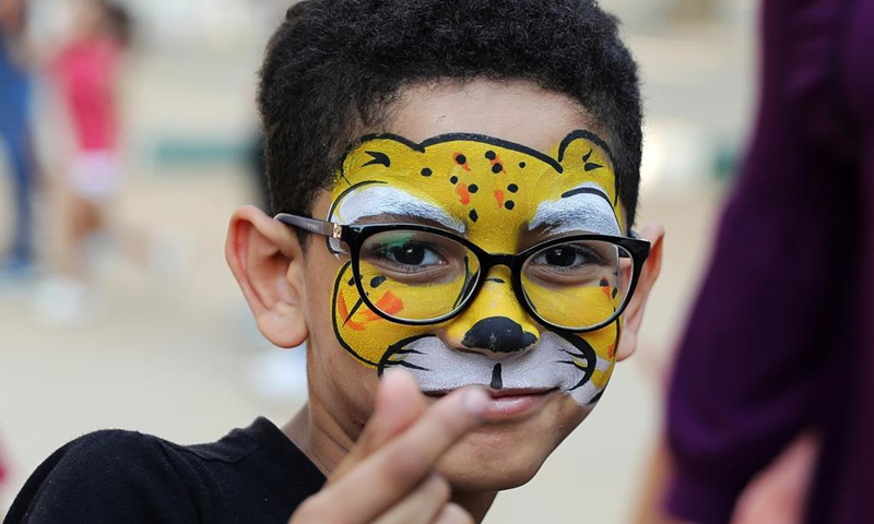A child with face painting poses for a photo at the Giza Zoo in Giza, Egypt, on Sept. 18, 2021. Opened in 1891 and as the largest zoo in Egypt and the Middle East, Giza Zoo is a main destination for Egyptian families with their children on holidays. (Xinhua/Wang Dongzhen)