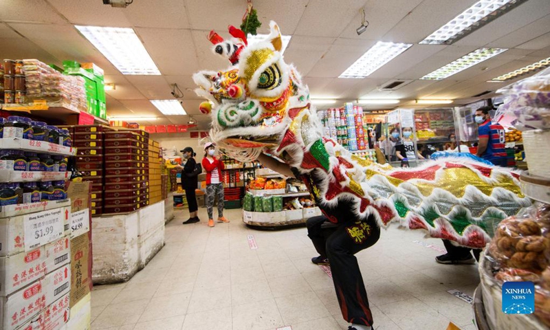 People perform a lion dance inside a grocery store at the Chinatown in Toronto, Canada, on Sept. 18, 2021. A traditional lion dance parade was held here on Saturday to celebrate the upcoming Mid-Autumn Festival. (Photo by Zou Zheng/Xinhua)