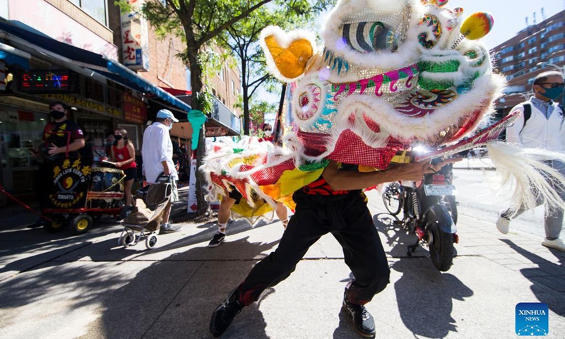 People perform a lion dance at the Chinatown in Toronto, Canada, on Sept. 18, 2021. A traditional lion dance parade was held here on Saturday to celebrate the upcoming Mid-Autumn Festival. (Photo by Zou Zheng/Xinhua) 