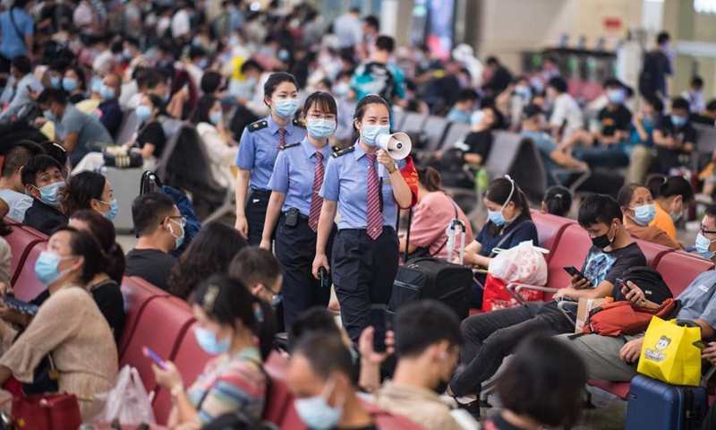 Staff members of Hankou Railway Station remind passengers to follow epidemic prevention rules in Wuhan, central China's Hubei Province, Sep 19, 2021, the first day of the 3-day Mid-Autumn Festival holiday.Photo:Xinhua