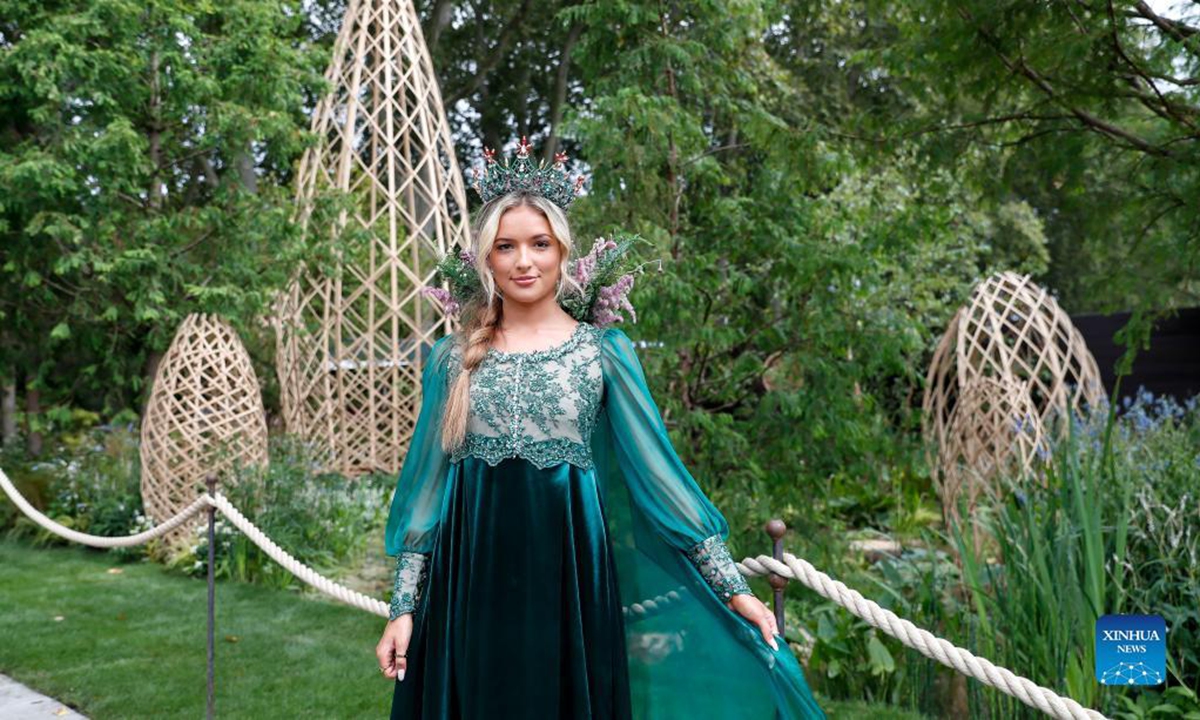 A girl poses in front of Guangzhou Garden at the RHS (Royal Horticultural Society) Chelsea Flower Show press day in London, Britain, on Sept. 20, 2021. The annual RHS Chelsea Flower Show will open to the public here from Sept. 21 to 26. (Xinhua/Han Yan)