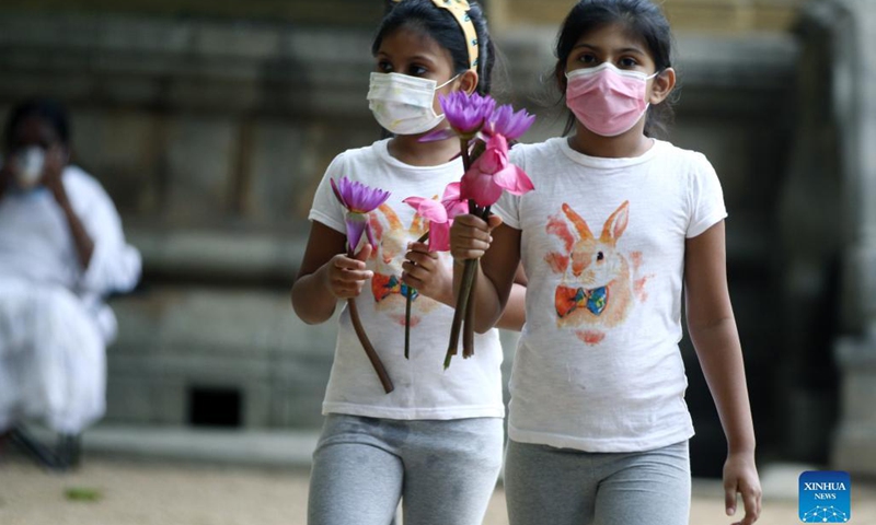 Two girls celebrate the Poya Day in the Kelaniya Temple in Kelaniya, Sri Lanka, Sept. 20, 2021. Poya day is a monthly holiday in Sri Lanka, marking the full moon. (Photo: Xinhua)