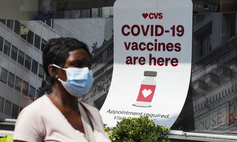 A person walks past a sign of COVID-19 vaccination at a pharmacy in New York, the United States, Aug. 11, 2021. (Photo: Xinhua)