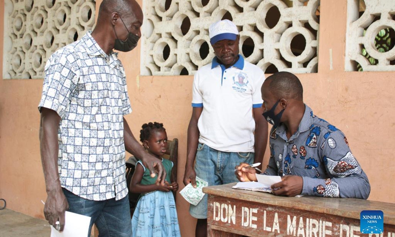 A man enrolls his daughter in school on the first day of a new school year in the village of Djegbadji in Ouidah, Benin, on Sept. 20, 2021.(Photo: Xinhua)