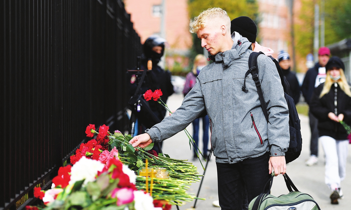 A man lays flowers at the entrance of the university campus in Perm, Russia on Monday, one day after a gunman killed six people on a university campus in Russia before being detained. Photo: AFP
