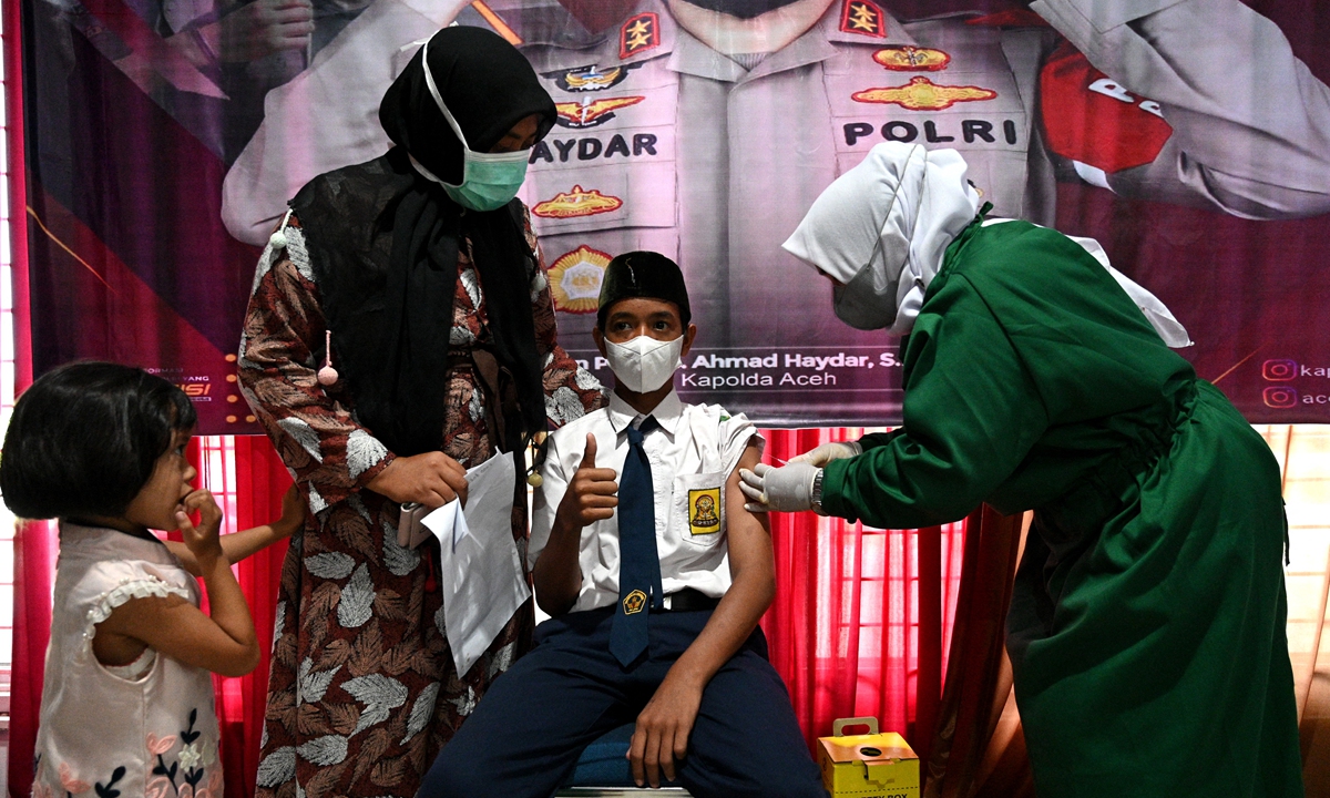 A junior high-school student receives a dose of the Sinovac vaccine at a vaccination drive in Blang Bintang, Aceh Province, Indonesia on Tuesday. The total COVID-19 vaccination in Indonesia has reached more than 100 million doses as of Tuesday. Photo: AFP