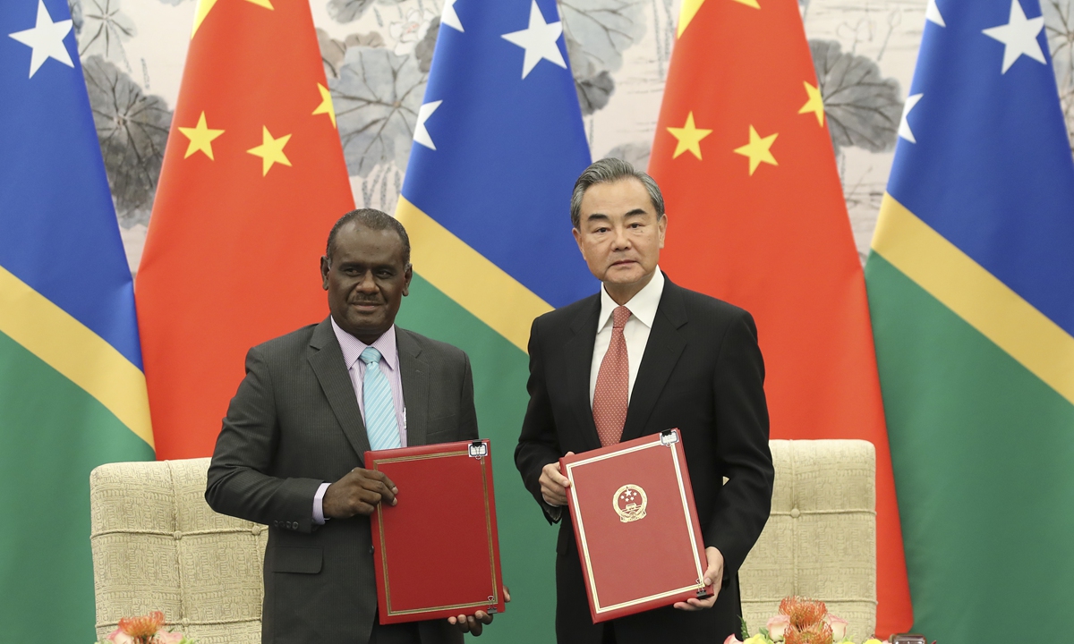 China's State Councilor and Foreign Minister Wang Yi (right) and the Solomon Islands' Minister of Foreign Affairs and External Trade Jeremiah Manele sign a joint communiqué on the establishment of diplomatic relations on September 21, 2019. Photo: cnsphoto