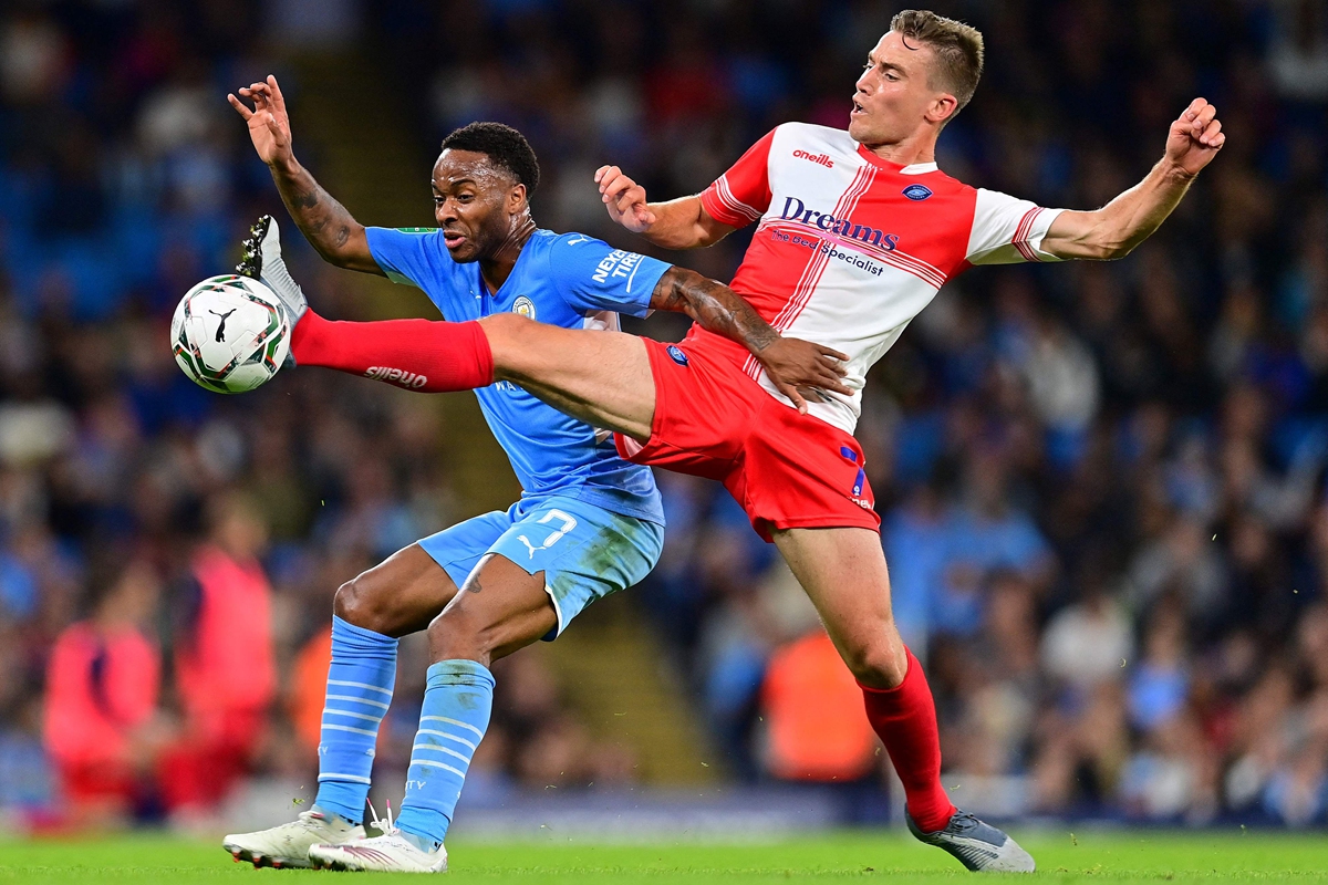 Manchester City's Raheem Sterling (left) vies with Wycombe Wanderers' David Wheeler on Tuesday in Manchester, England. Photo: VCG