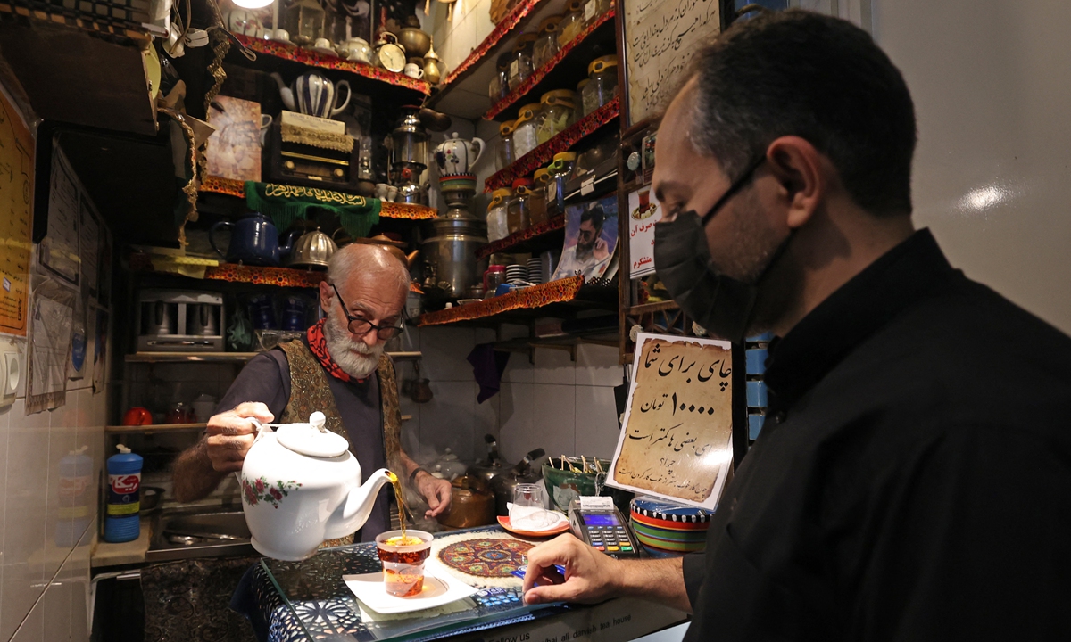 Owner Kazem Mabhutian, 63, serves tea at the smallest and oldest teahouse tucked away in an alleyway of the Grand Bazaar in the Iranian capital Tehran on Monday. Photo: AFP