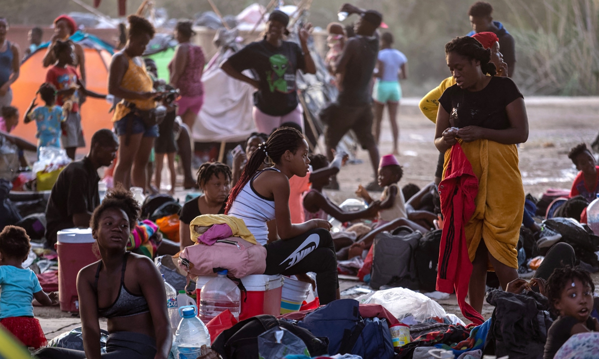 Immigrants sit and lie under the international bridge at a migrant camp on the US-Mexico border on Tuesday in Del Rio, Texas. Photo: AFP