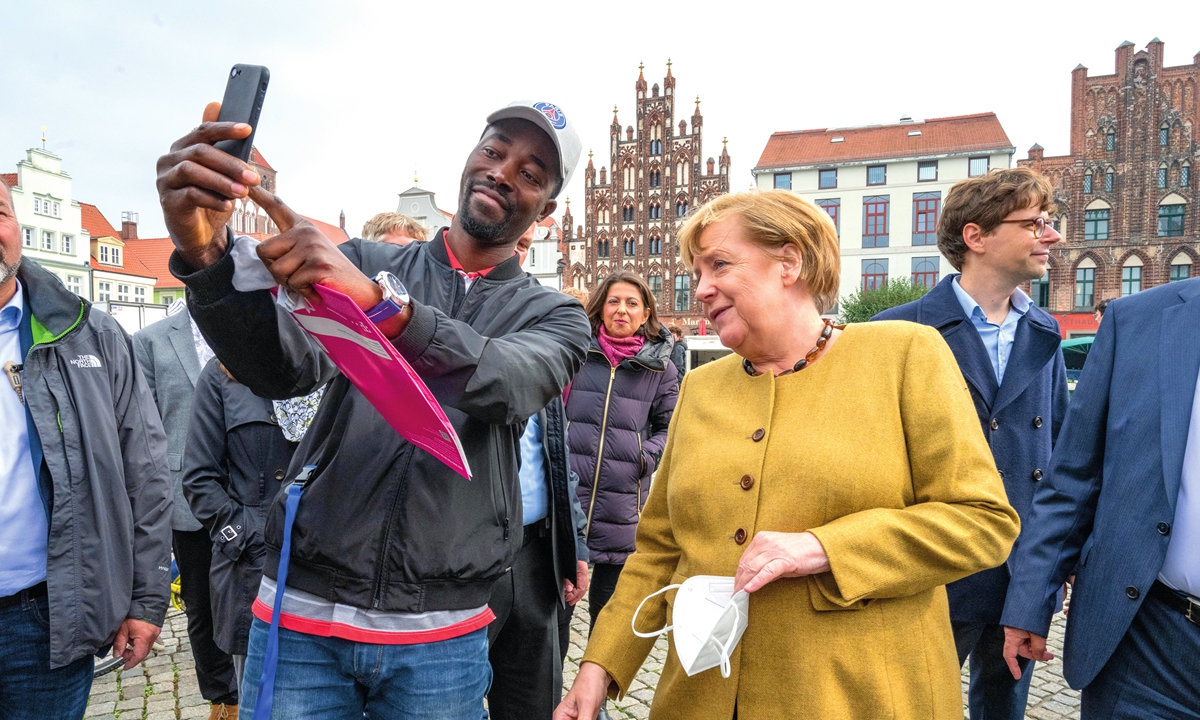 German Chancellor Angela Merkel (right) has her picture taken with a visitor on Thursday at the weekly market in her former constituency in Greifswald before the federal election. The outgoing chancellor had come to Mecklenburg-Western Pomerania for a surprise visit. Photo: AFP