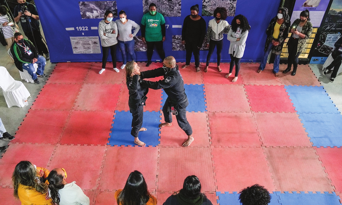 Instructors demonstrate Jiu Jitsu techniques to a group of women in the Paraisopolis favela of Sao Paulo, Brazil, on Wednesday. Dozens of women in the Paraisopolis community are training to learn how to defend themselves from attack in a country with high levels of violence against women.  Photo: VCG