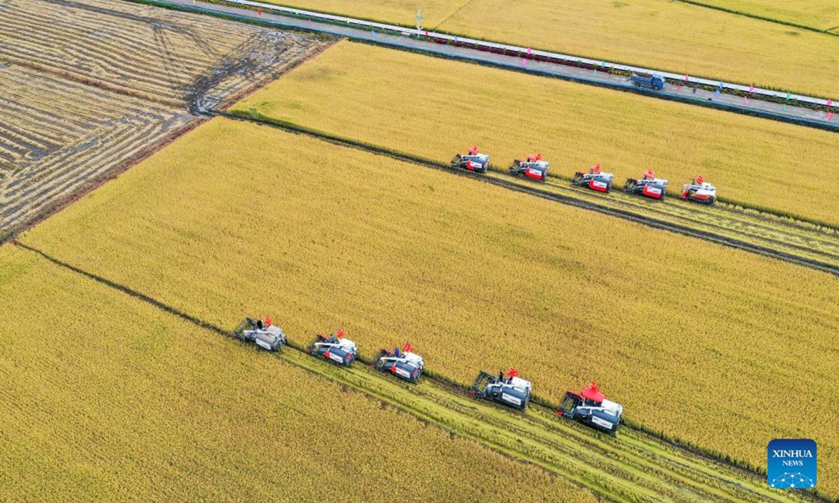Aerial photo taken on Sept. 23, 2021 shows farmers operating rice harvesters during an demonstration event in celebration of the Chinese farmers' harvest festival at Hongguang Village, Changchun City of northeast China's Jilin Province. Thursday marks the Chinese farmers' harvest festival, which is celebrated on the Autumn Equinox. (Xinhua/Zhang Nan)