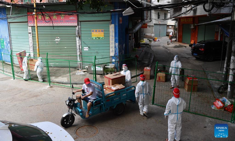 Staff members for COVID-19 response deliver food for residents under quarantine at the Xihu community in Tongan District of Xiamen City, southeast China's Fujian Province, Sept. 23, 2021.Photo:Xinhua