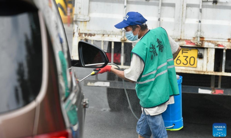 A staff member disinfects a vehicle at an exit of an expressway according to a protocol to curb COVID-19 in Tongan District of Xiamen City, southeast China's Fujian Province, Sept. 23, 2021.Photo:Xinhua