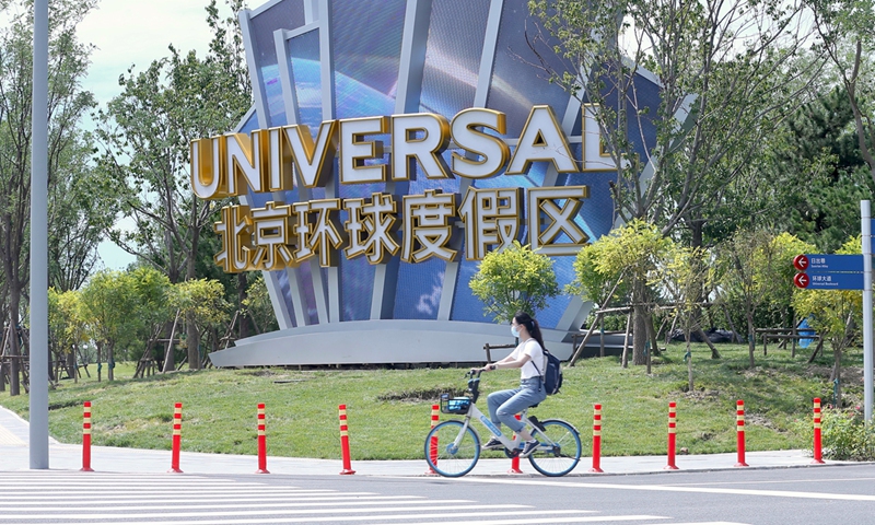 A woman rides a bicycle at the Beijing's Universal Studios Resort. Photo: cnsphoto
