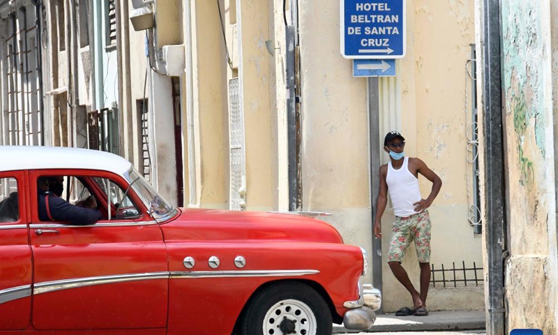 People wearing face masks walk on the street in Havana, Cuba, Sept. 25, 2021. (Photo by Joaquin Hernandez/Xinhua)