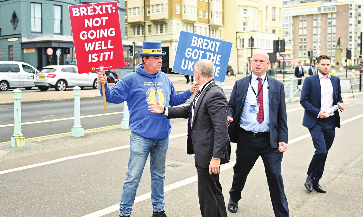 Security stops anti-Brexit activist Steve Bray approaching Britain's main opposition Labor Party leader Keir Starmer (unseen) as he walks along the seafront to attend an interview, on the second day of the annual Labor Party conference in Brighton, southern England on Sunday. Photo: AFP