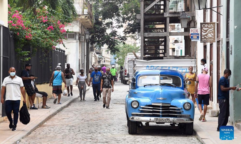 People wearing face masks walk on the street in Havana, Cuba, Sept. 25, 2021. (Photo by Joaquin Hernandez/Xinhua)
