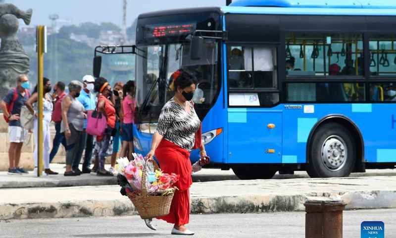People wearing face masks walk on the street in Havana, Cuba, Sept. 25, 2021. (Photo by Joaquin Hernandez/Xinhua)