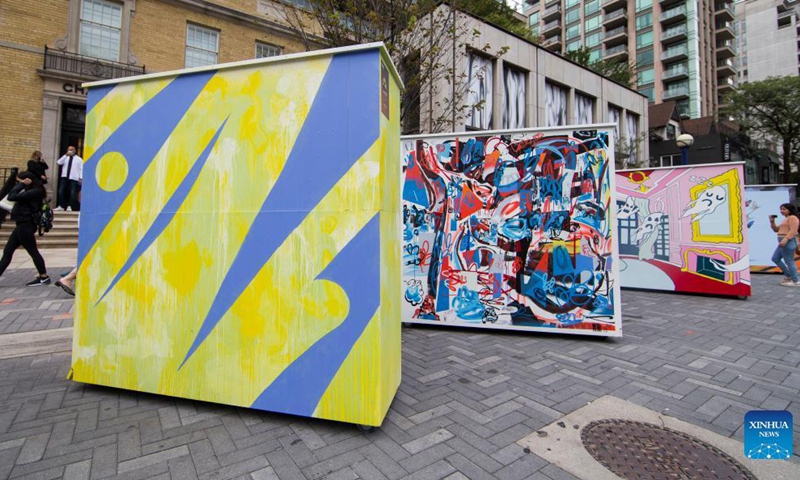 A woman looks at murals during the 2021 Yorkville Murals art festival in Toronto, Canada, on Sept. 26, 2021.(Photo: Xinhua)