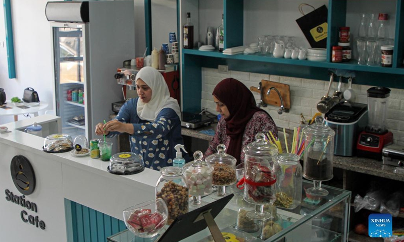 Palestinian sisters Ahlam (R) and Marwa Khadra work at their own cafe Station Cafe in Gaza City, on Sept. 27, 2021. As the Gaza Strip has long been under the threat of high unemployment rate, many Palestinian women there have to rely on their own wits to make a living.(Photo: Xinhua)